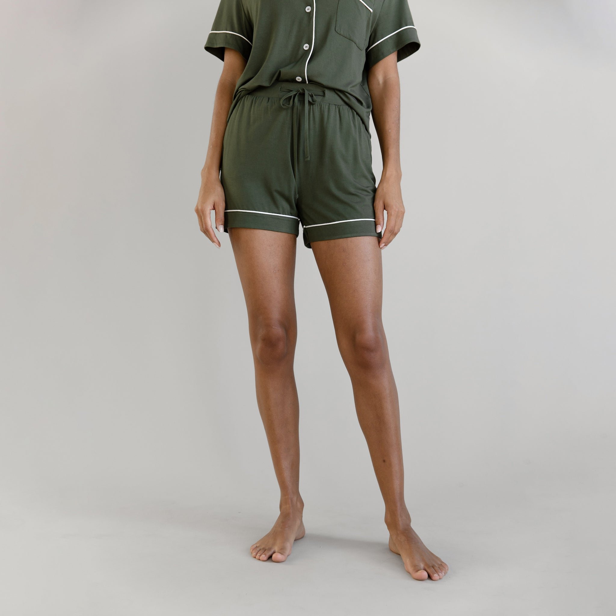 Olive Short Sleeve Pajama Set modeled by a women. The photo was taken in a light setting; showing off the pajamas. 