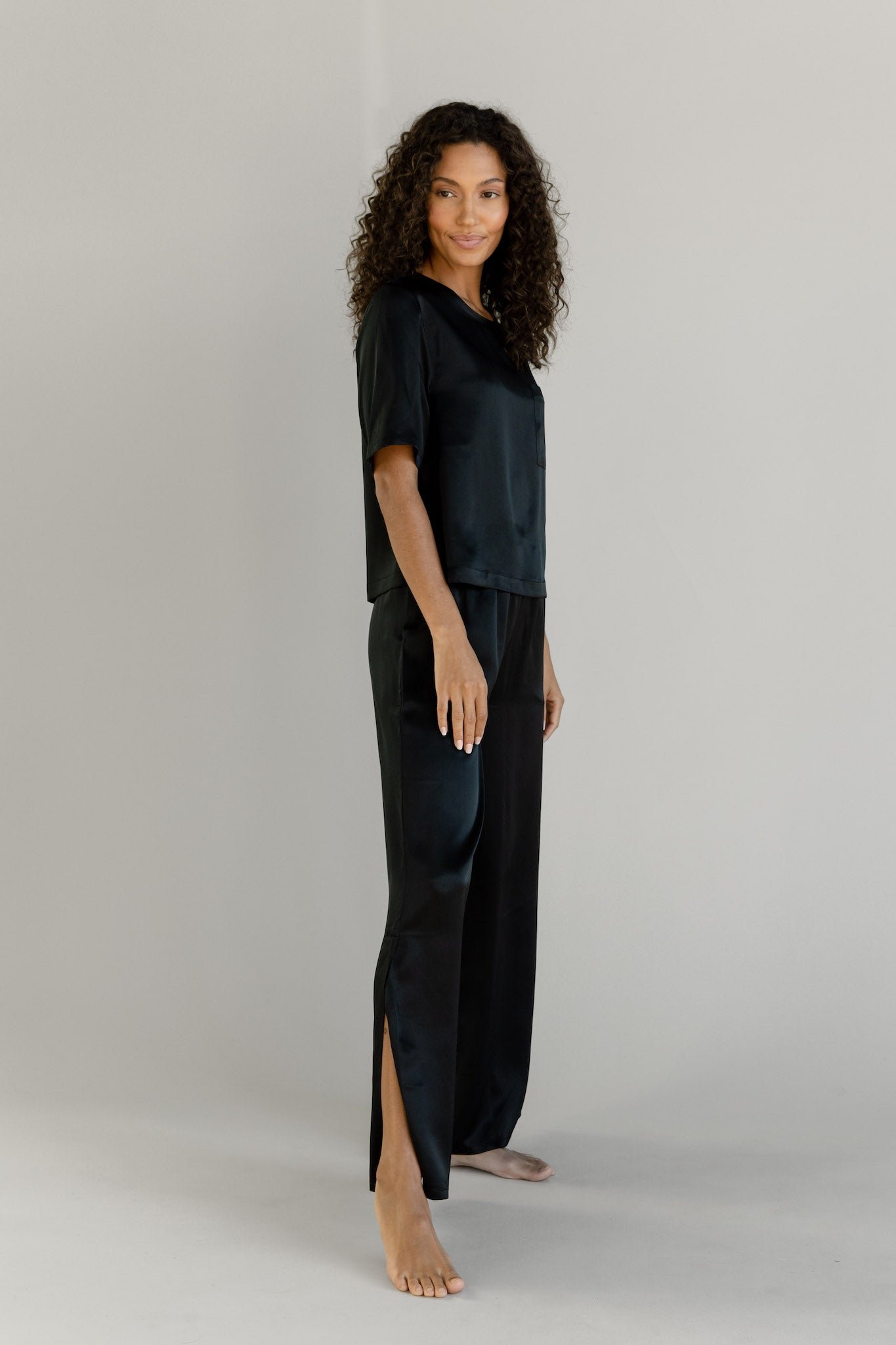 Black Serenity Silk Scoop Neck Tee modeled by a woman. The photo was taken in a high contrast setting, showing off the colors and lines of the tee. 