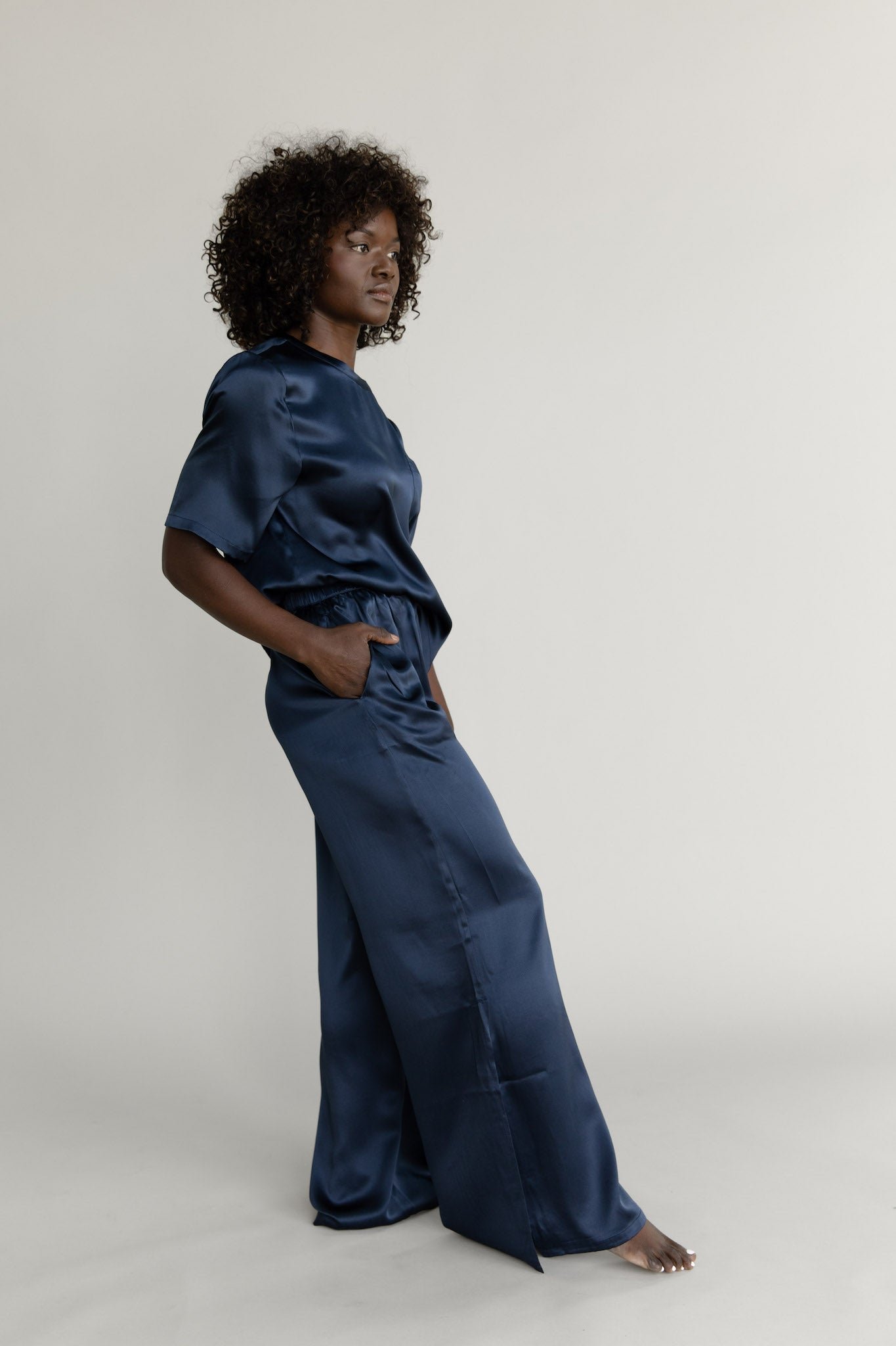 Navy Serenity Silk Scoop Neck Tee modeled by a woman. The photo was taken in a high contrast setting, showing off the colors and lines of the tee. 