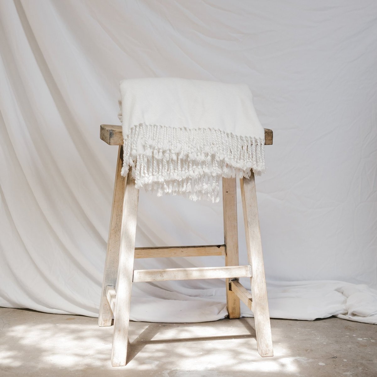 White Bamboo Throw Blanket draped over wooden stool 