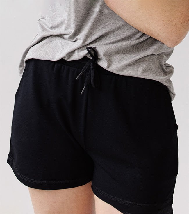 Person wearing Cozy Earth Brushed Bamboo Jogger Shorts in black and a gray top 