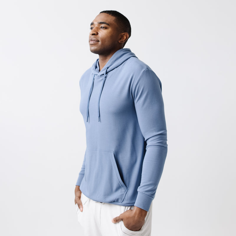 Blue Bamboo Hoodie worn by a man standing in front of white background.