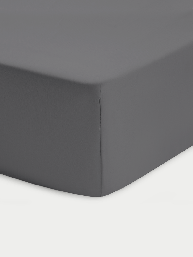 Corner of charcoal crib sheet with white background