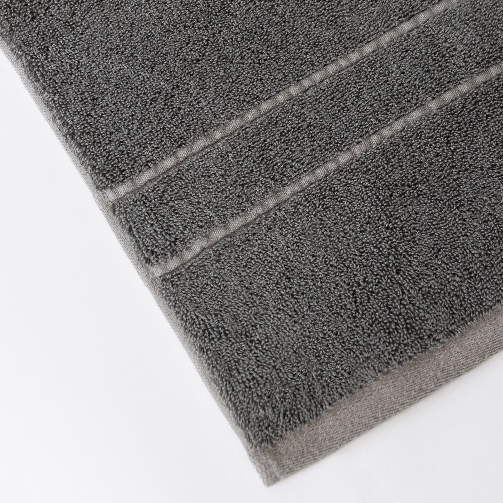 Premium Plush Bath Towels in the color Charcoal. Photo of Premium Plush Bath Towels taken on a white background showing only the corner of the towel. 