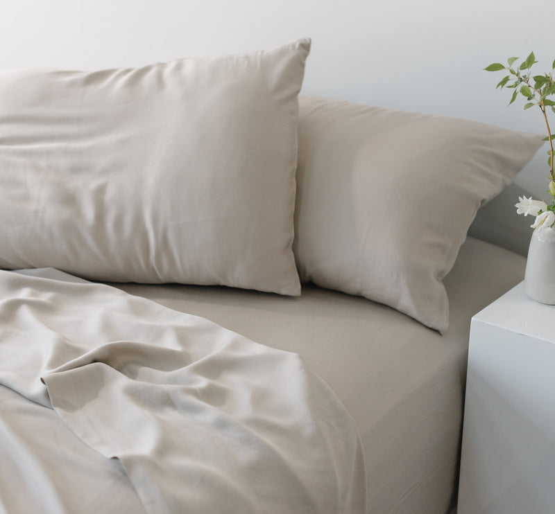 Unmade bed with driftwood bedding