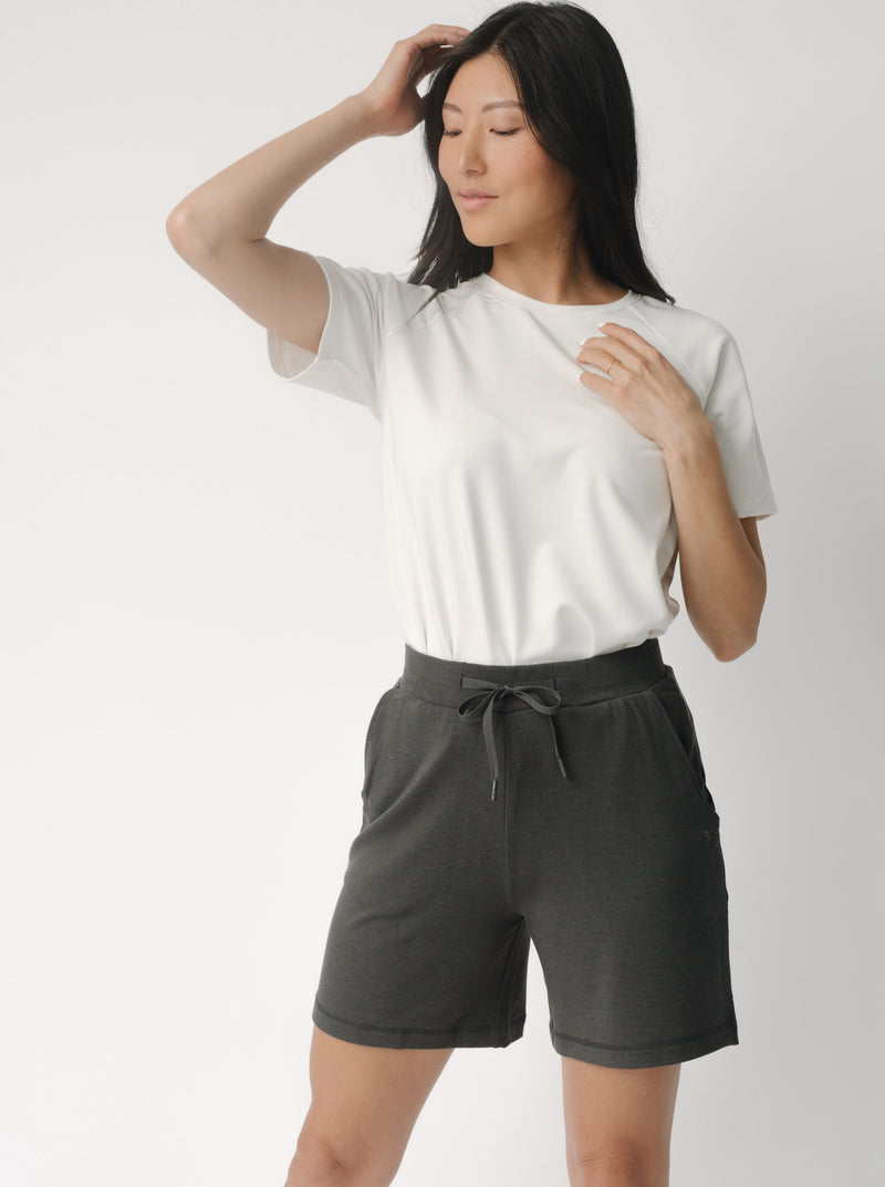 Woman wearing a white t-shirt and grey Cozy Earth Brushed Bamboo Mid-Length Shorts shorts on a plain background