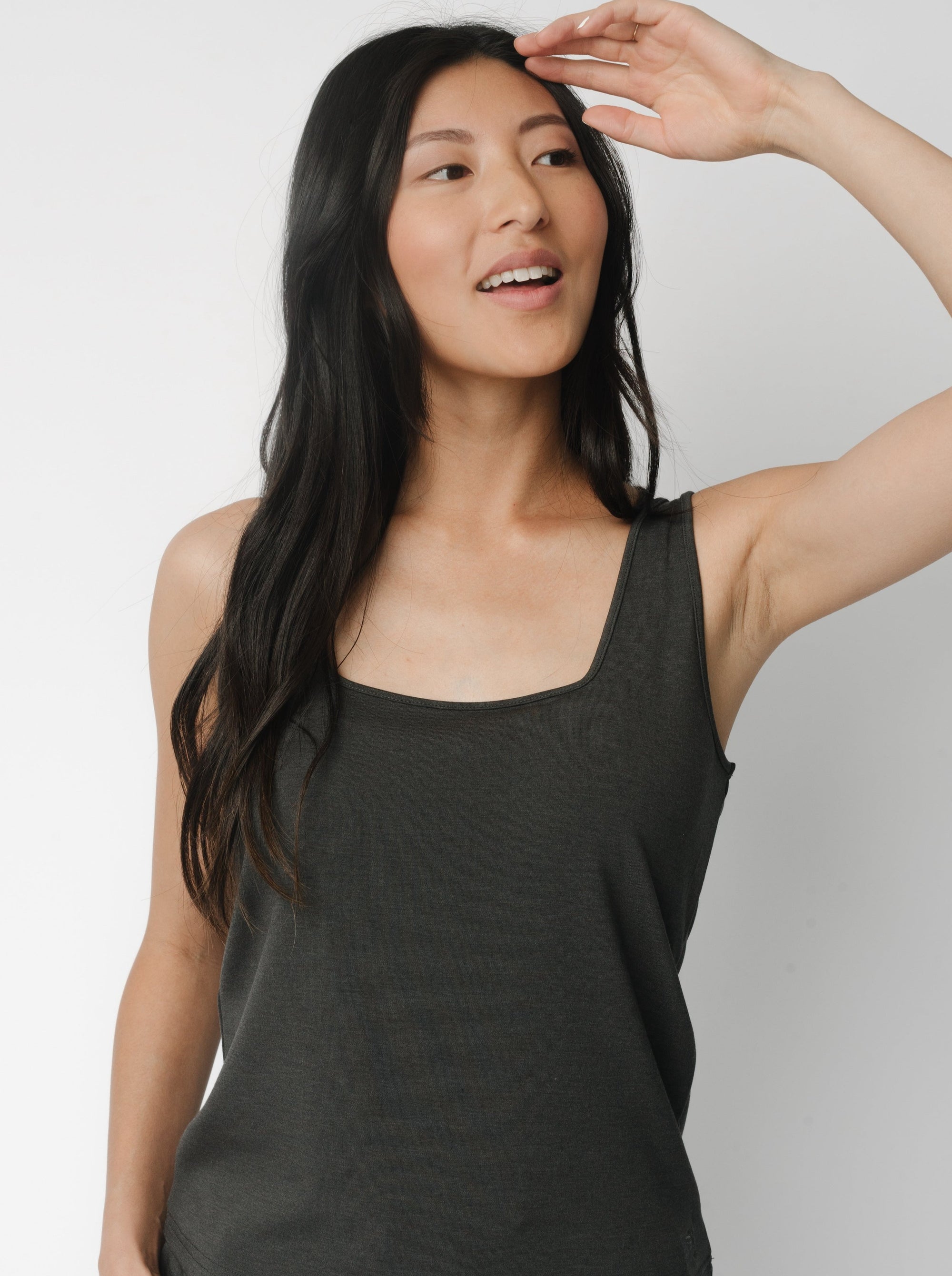 A woman wears Charcoal Women’s Ultra-Soft Bamboo Square Neck Tank in front of a white background 
