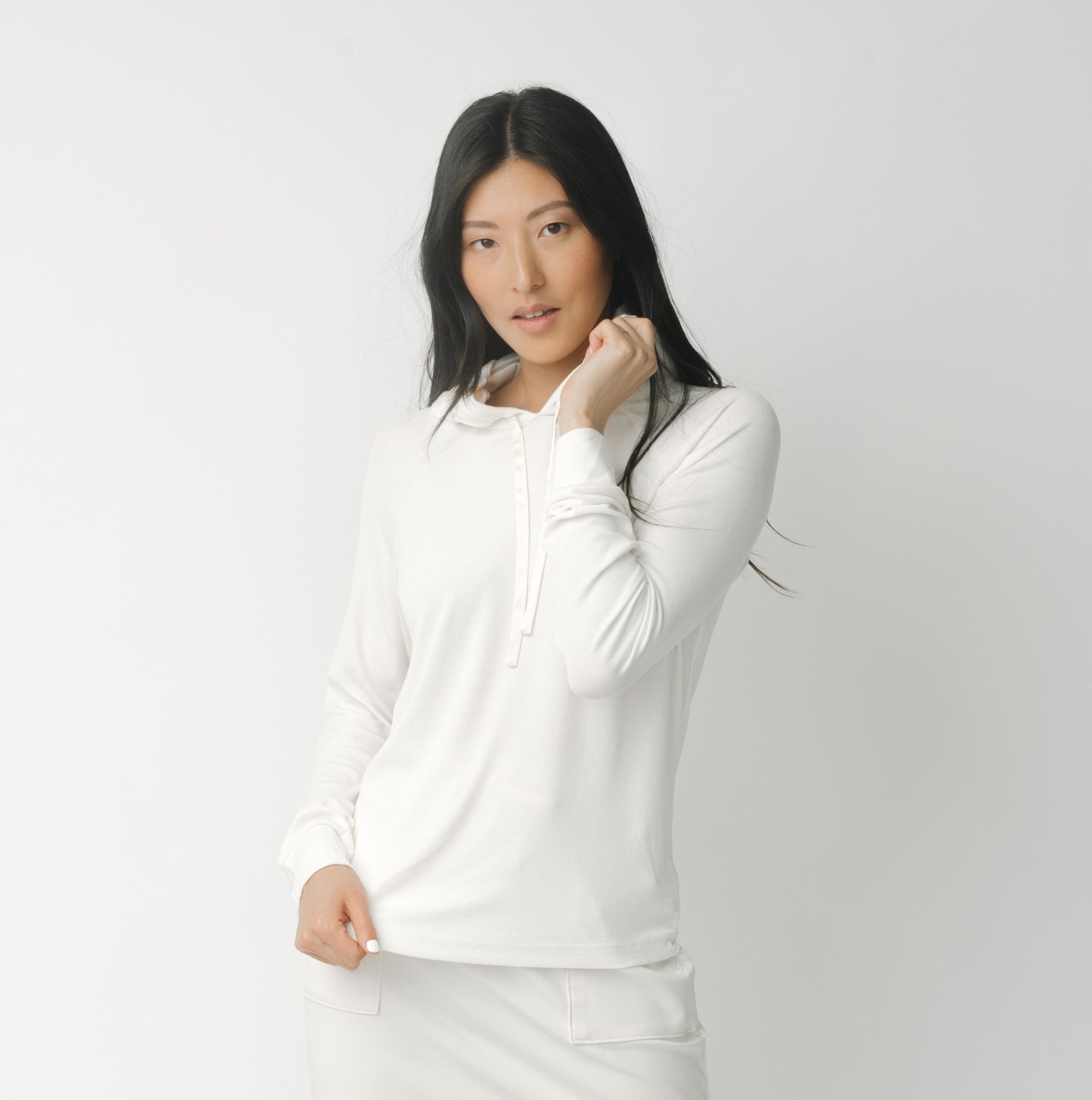 A woman wearing a white Cozy Earth Brushed Bamboo Hoodie against a plain background 