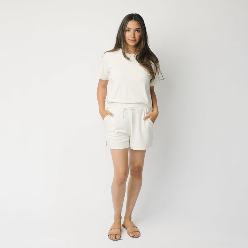 Woman wearing a white t-shirt and white Cozy Earth Brushed Bamboo Shorts shorts on a plain background
