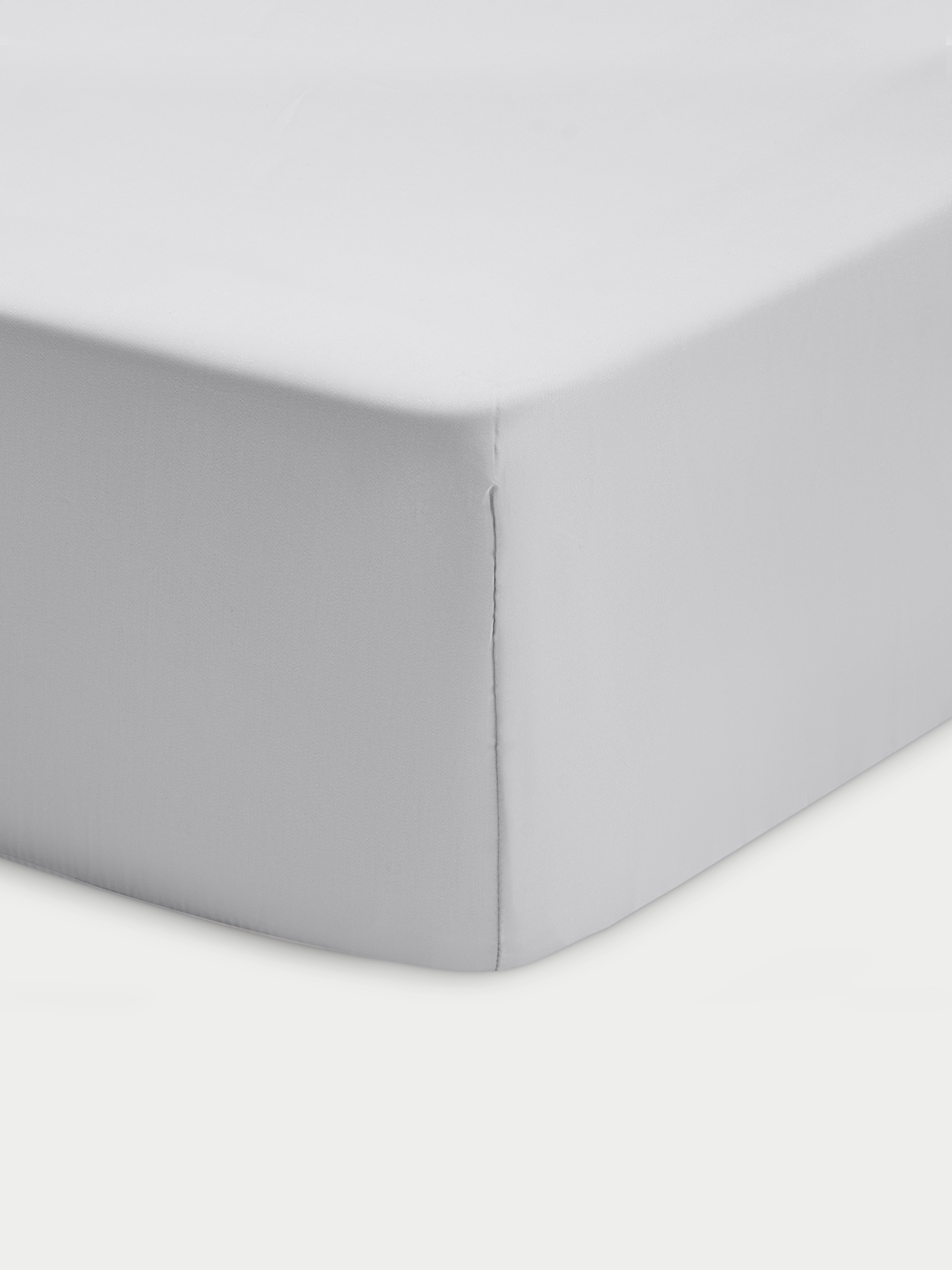 Corner of light grey crib sheet with white background 