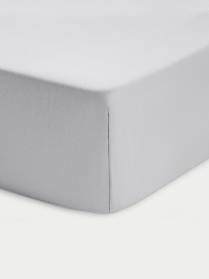 Corner of light grey crib sheet with white background