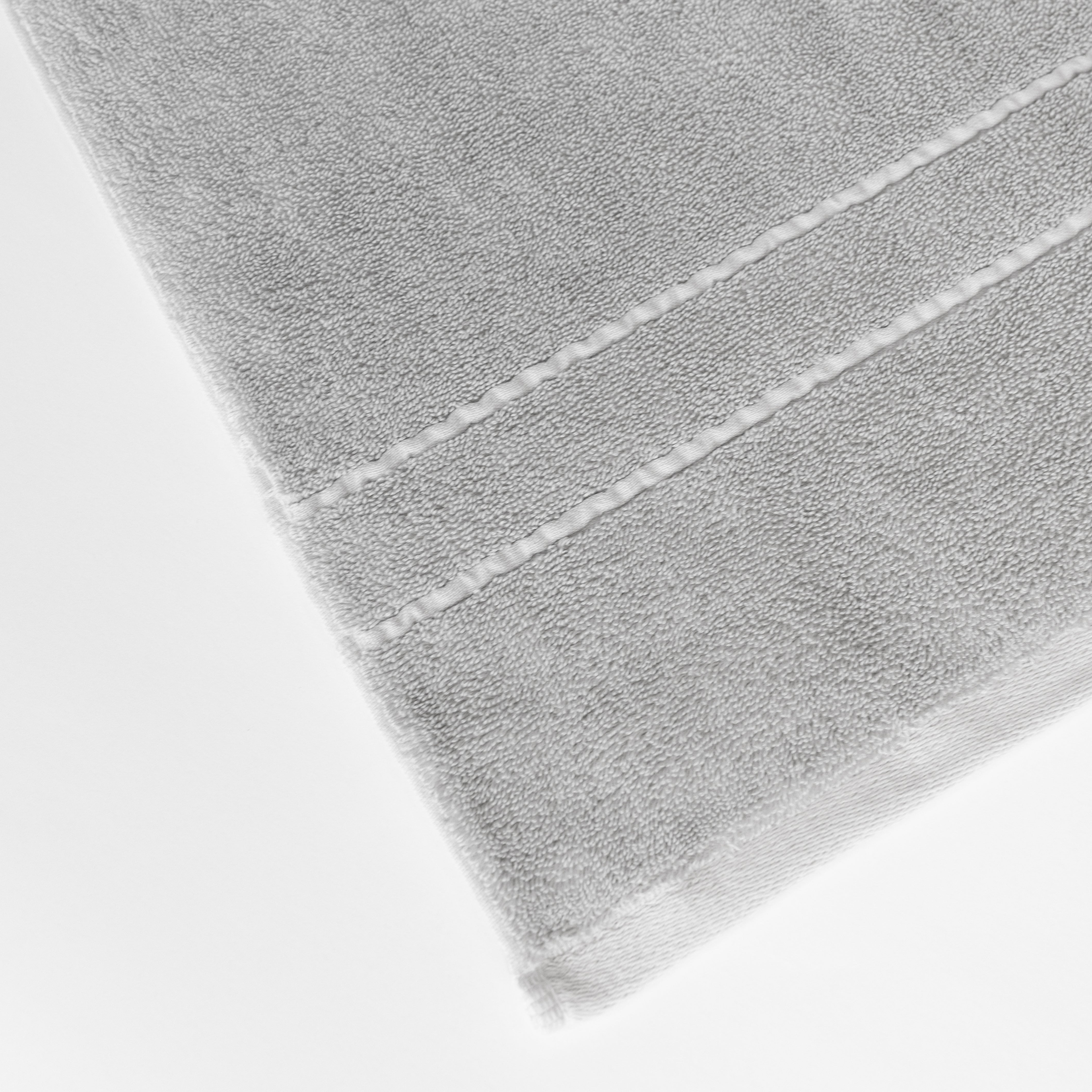 Premium Plush Bath Towels in the color Light Grey. Photo of Premium Plush Bath Towels taken on a white background showing only the corner of the towel. |Color: Light Grey