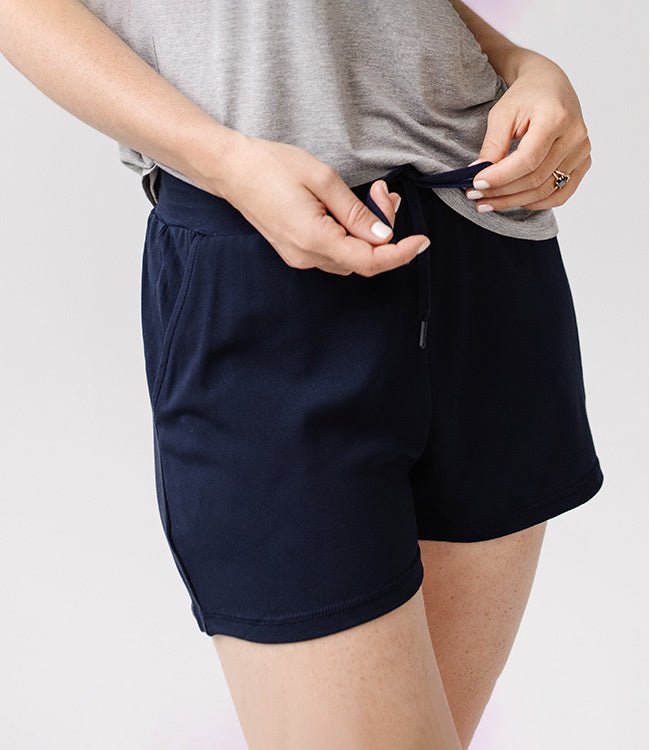 Person wearing Cozy Earth Brushed Bamboo Jogger Shorts in navy and a gray top on a light background 