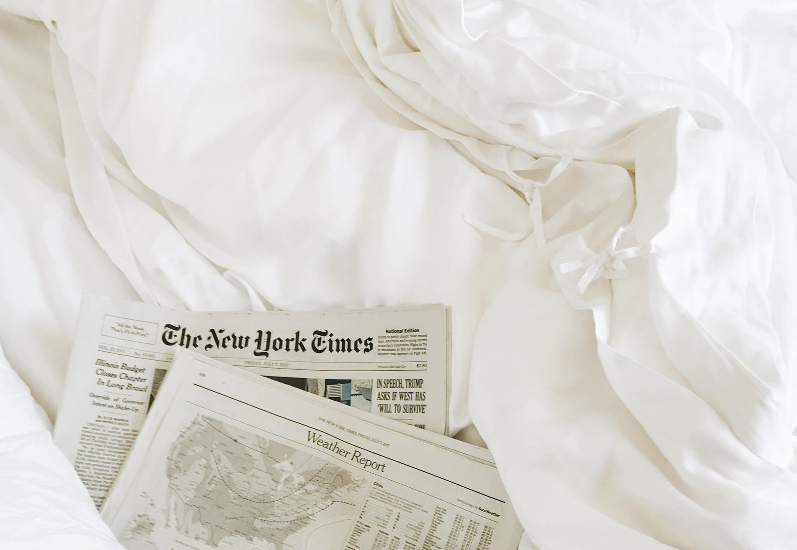 Close up of white duvet cover ties with newspapers to the side 