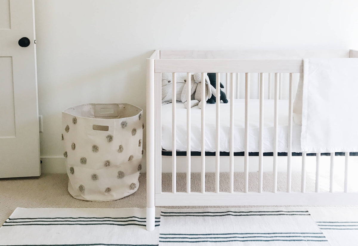 wooden crib bed made with white bamboo crib sheet 
