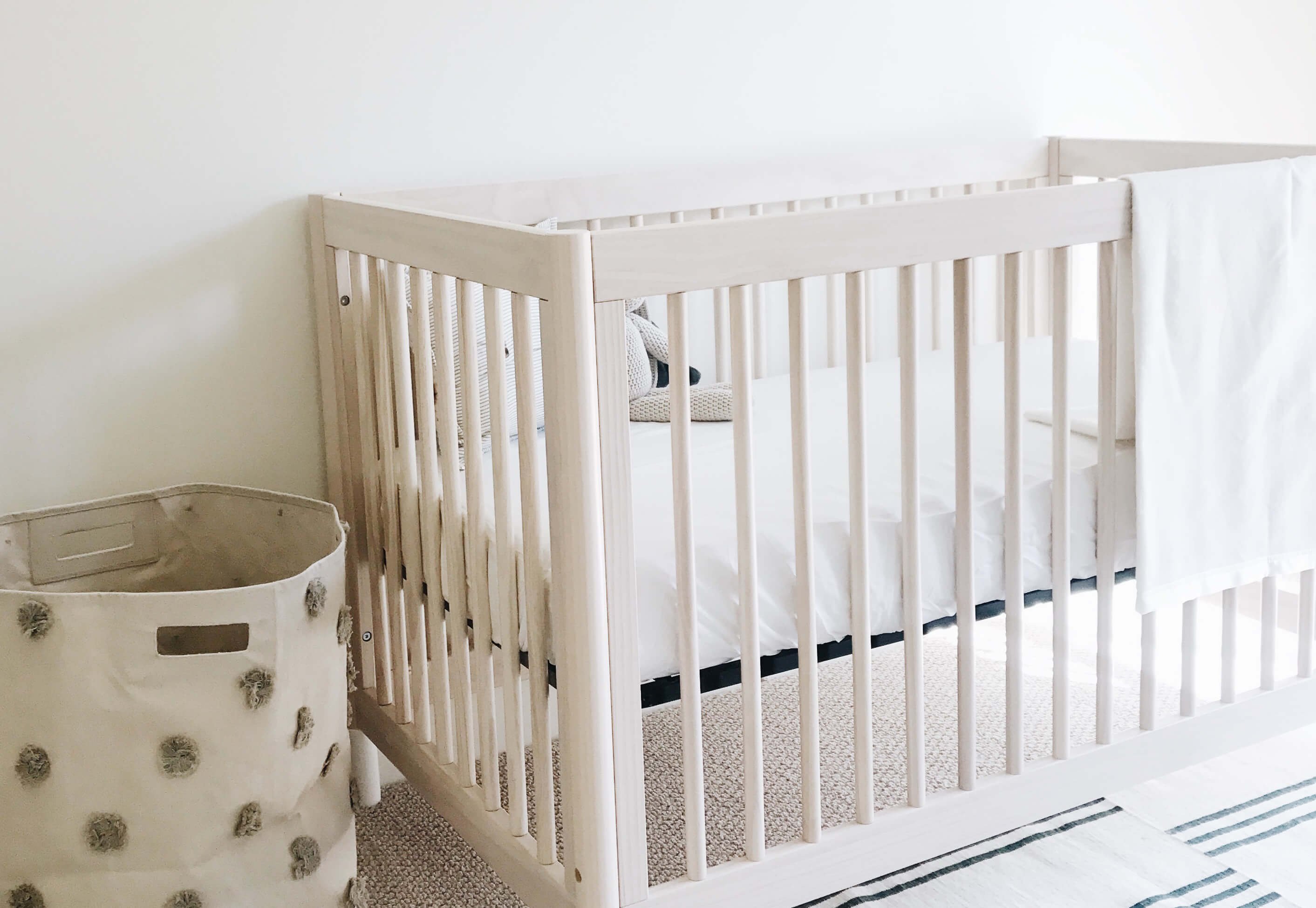 Wooden crib bed made with white bamboo crib sheets 