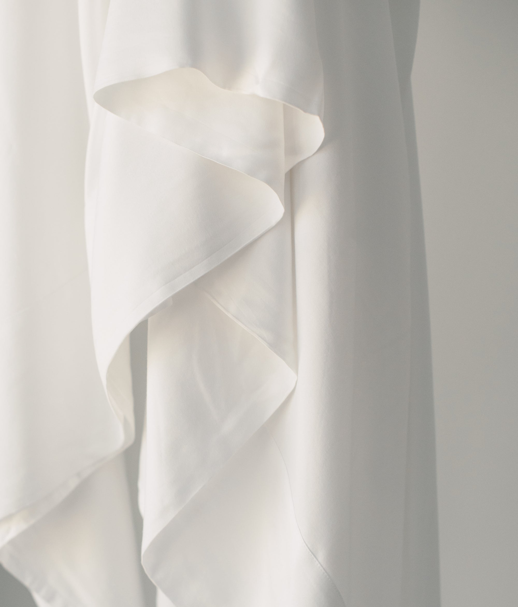 Close up of white sheet draped off of something 