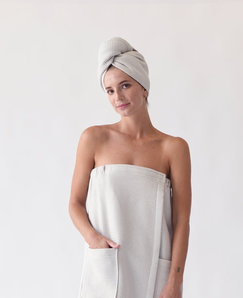 Light Grey Waffle Hair Towel. The hair towel is shown being worn by a woman. The photo was taken with a white background. |Color:Light Grey