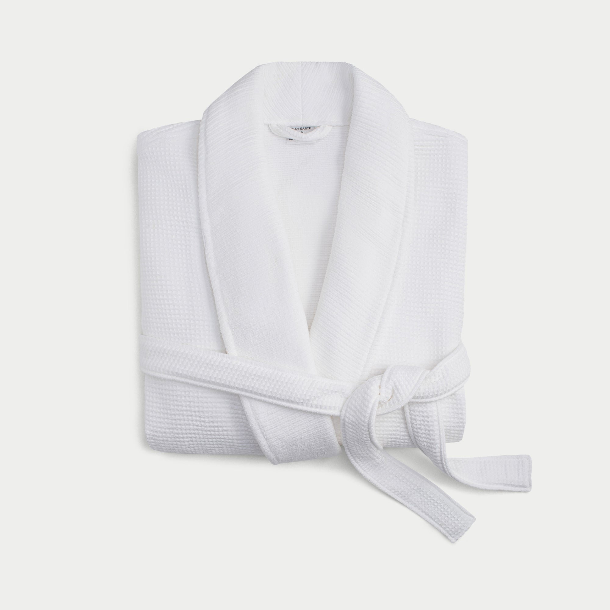 White bamboo waffle knit robe shown neatly folded with a white background. 