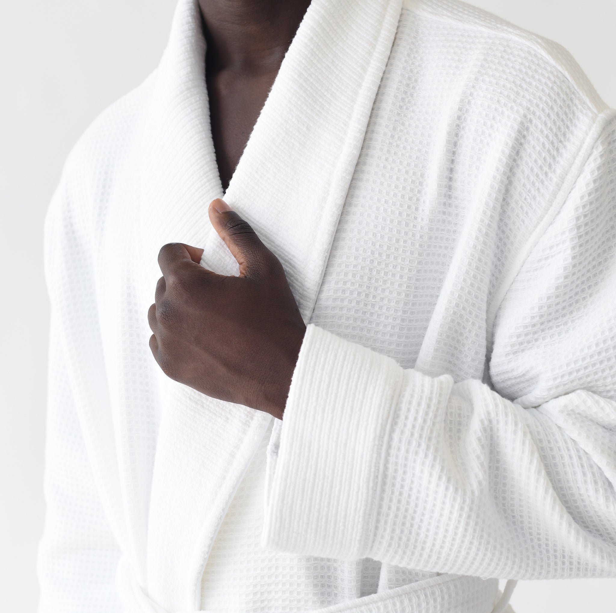 Man photographed from chest down wearing Bamboo Waffle Bath robe standing in front of a with a white background. 