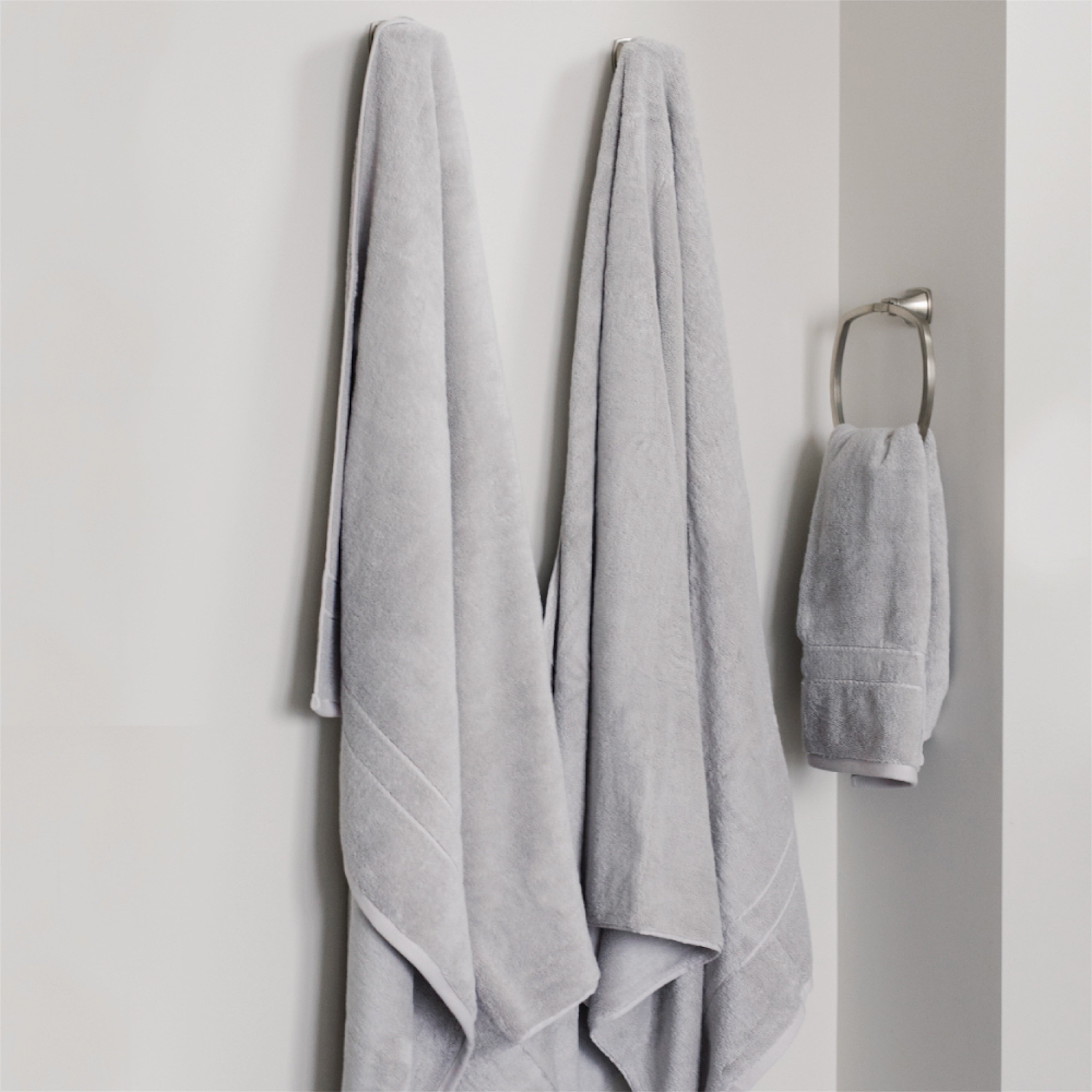 Premium Plush Bath Towels in the color Light Grey. Photo of Premium Plush Bath Towels taken in a bathroom showing the towels which are hung from a towel rack. |Color:Light Grey