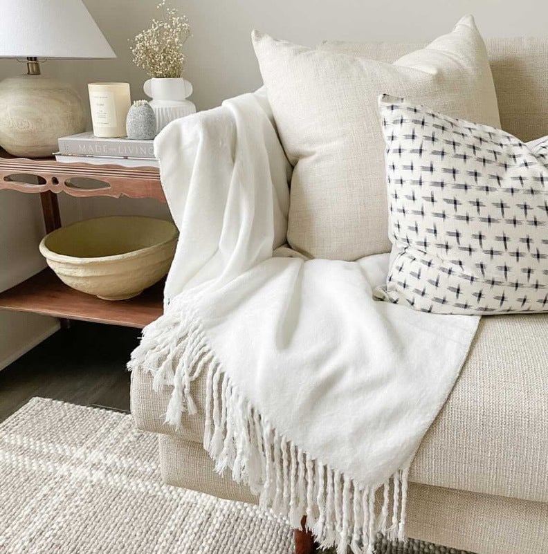 White Bamboo Throw Blanket on creme colored couch in living room 