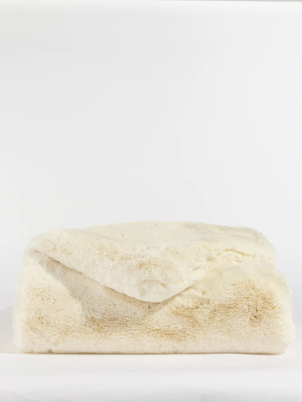 A plush, folded beige faux fur blanket on a white background.