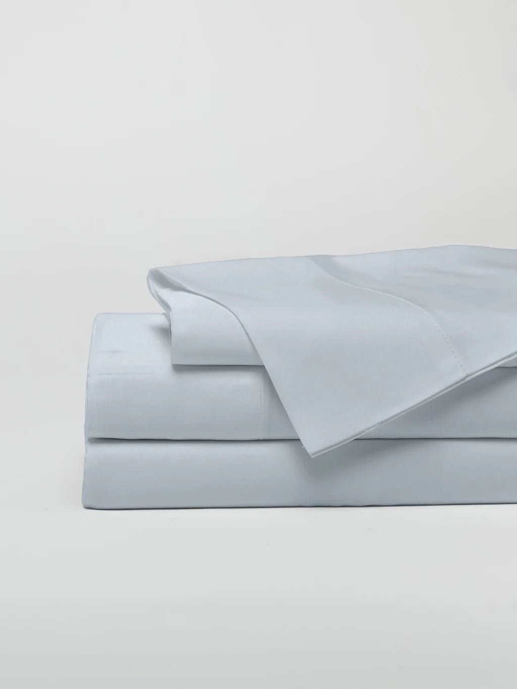 A neatly folded set of light gray bed sheets.