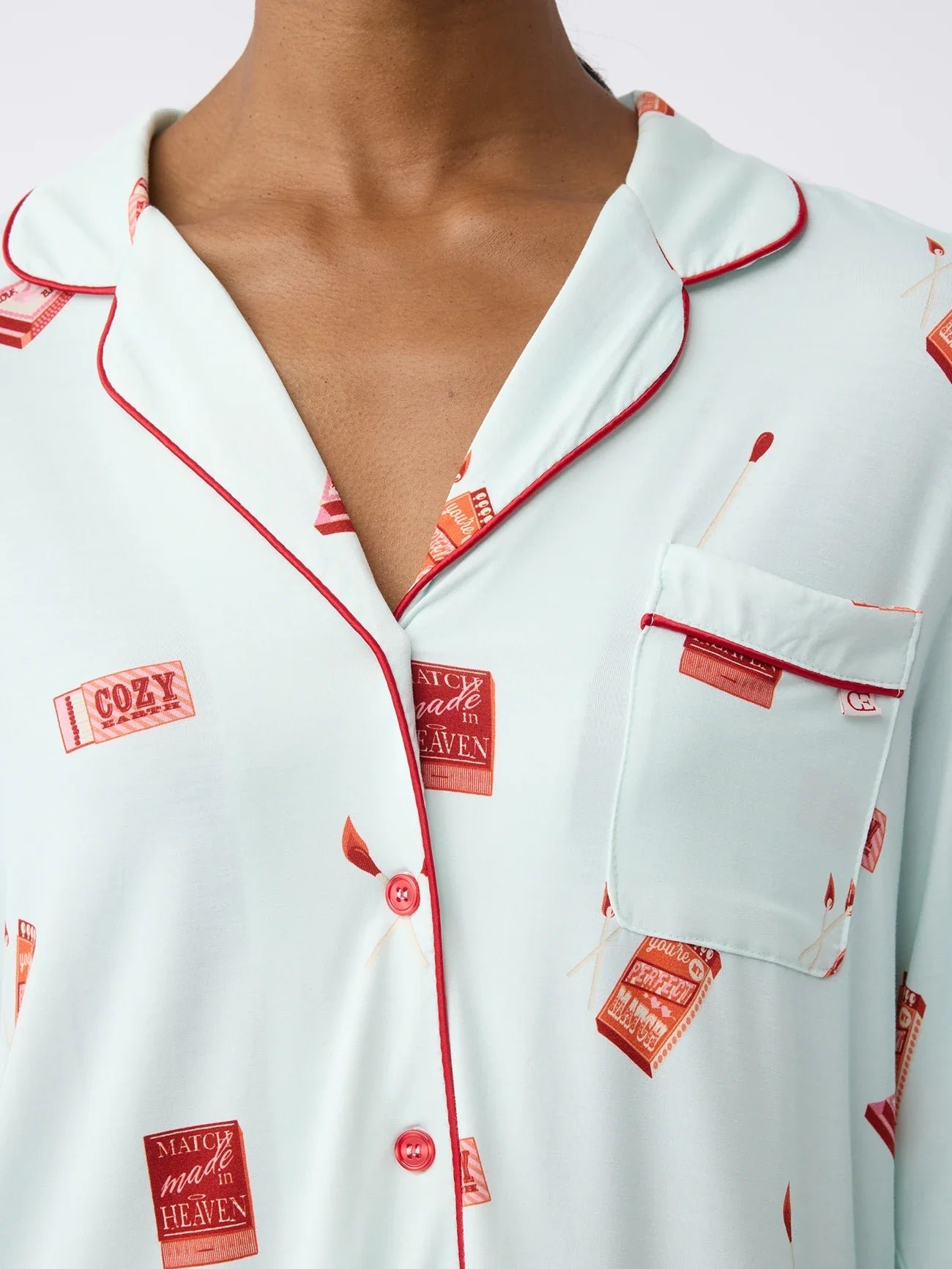 Light blue pajama top with red buttons and matchbox print design.