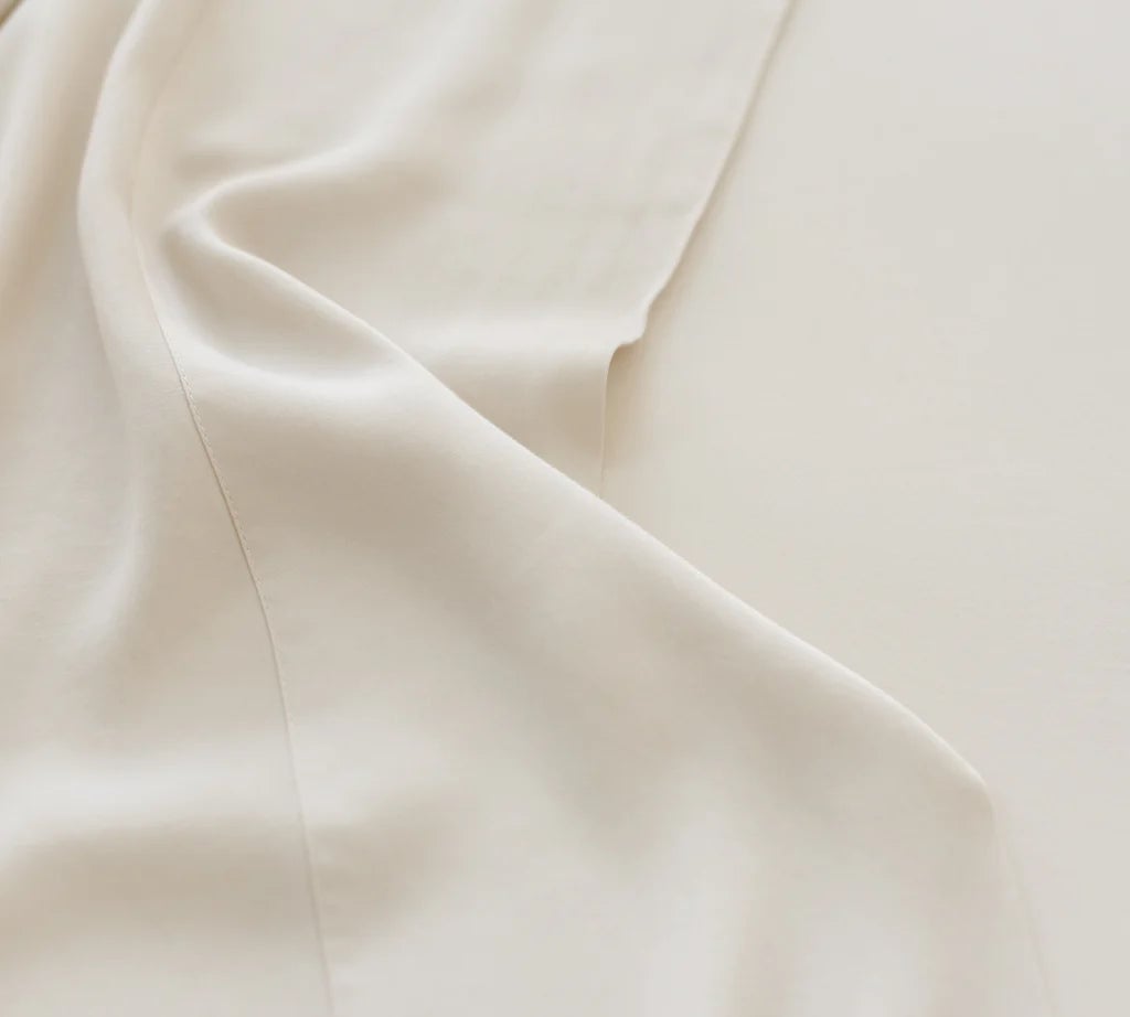 Cream-colored fabric with subtle, soft folds.
