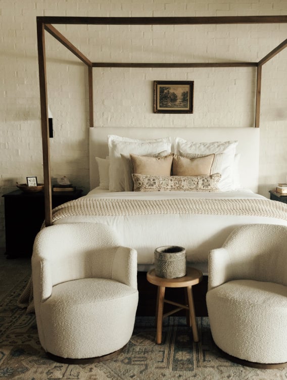 Large bed with two sofa chairs in front.