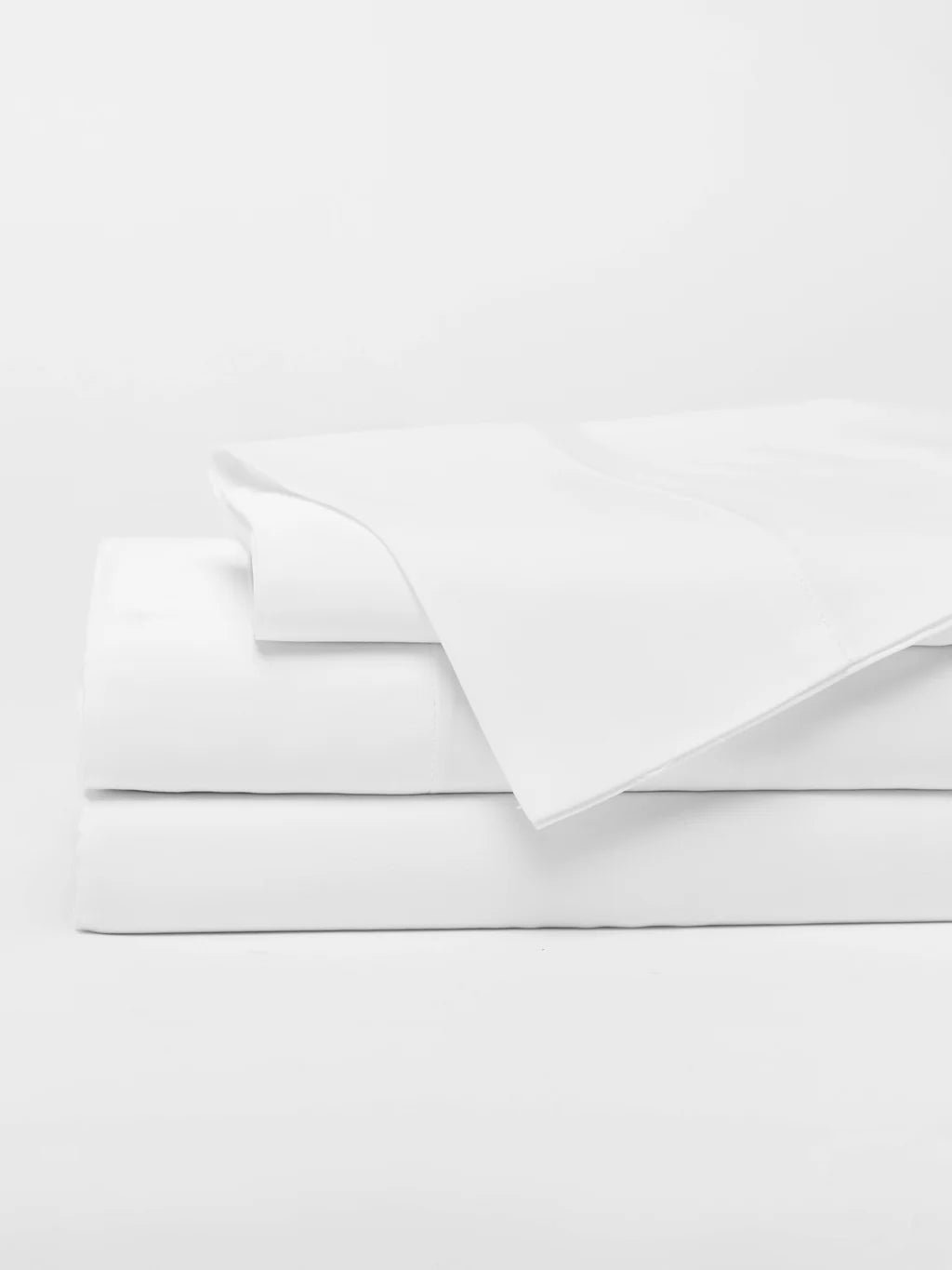 A stack of folded white bed sheets.